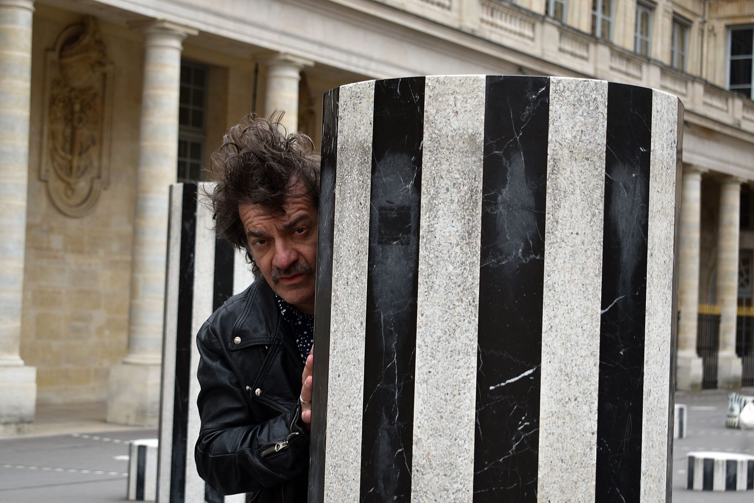 Peppe Voltarelli fotografato da Danilo Samà alle Colonnes de Buren nella Cour d'honneur del Palais-Royal di Parigi nel 2023