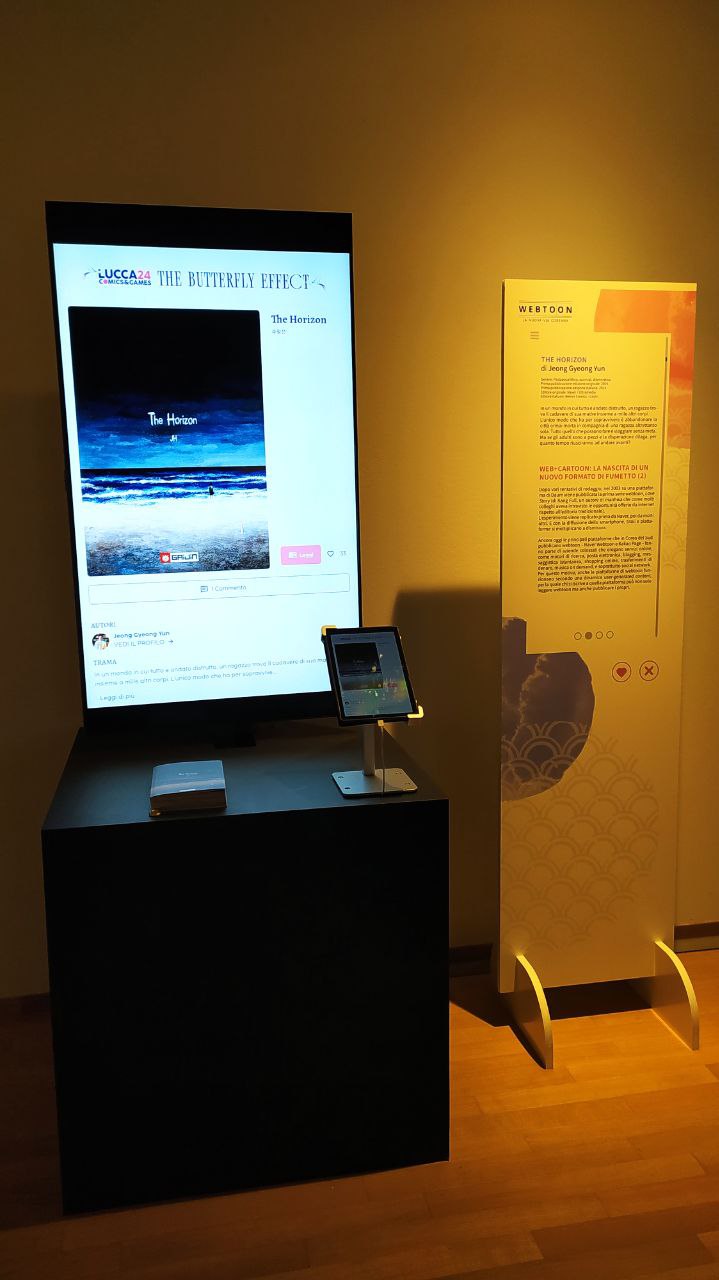 la mostra sui webtoon coreani presenta delle postazioni di lettura dove il fruitore può sperimentare il formato di lettura web verticale sui table oppure leggerlo tramite il formato cartaceo tradizionale. Foto di Camilla Rossini