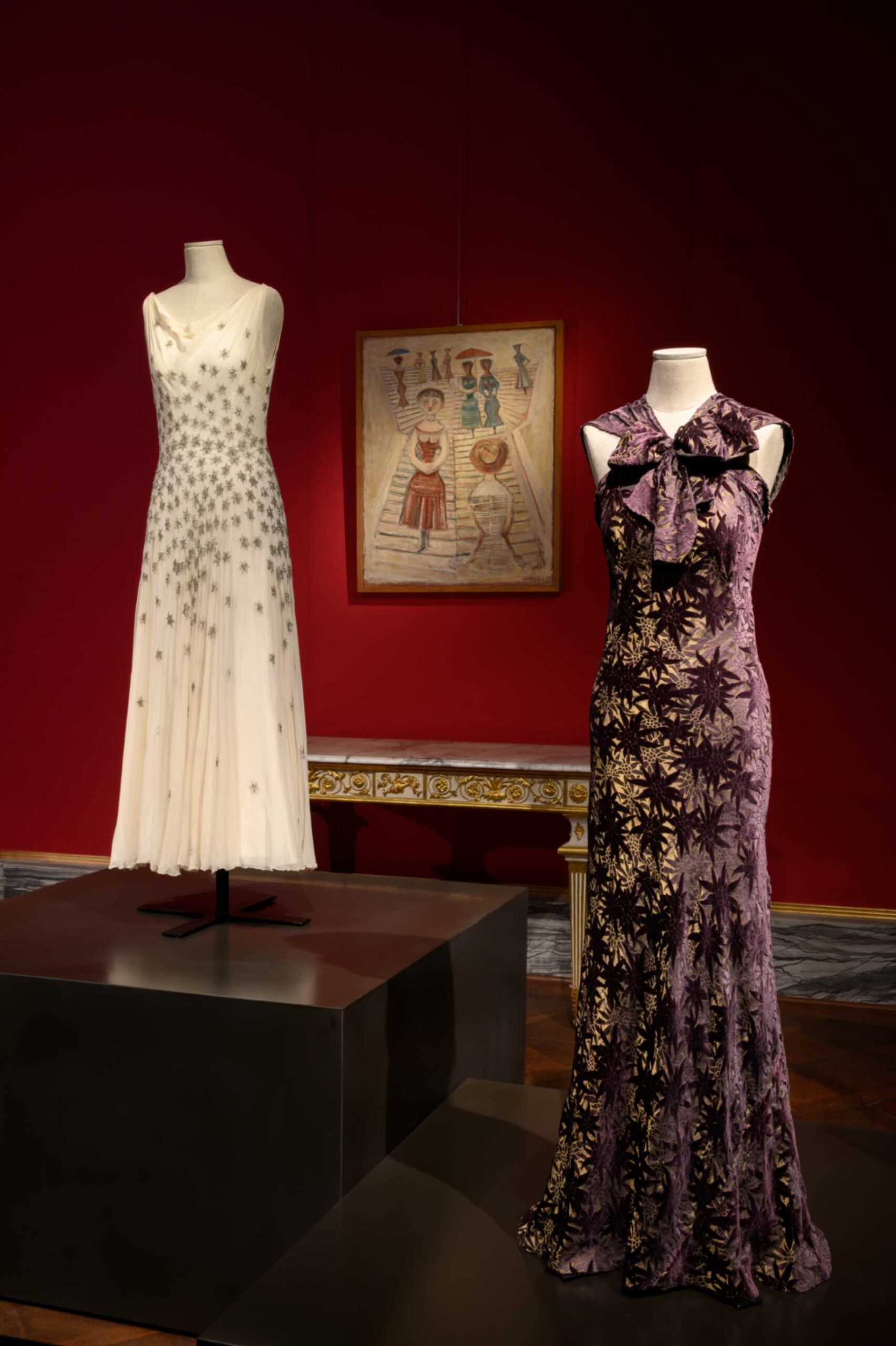 SALA 9 dettaglio Abito bianco da sera in chiffon di seta avorio di Madeleine Vionnet e abito in velluto di seta color viola prugna di manifattura italiana. Alla parete la Scalinata di Massimo Campigli (1955)